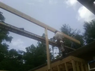 Carpenter setting a ridge beam over a new addition frame — Ice Dam Removal by Roofing Brothers in Piscataway