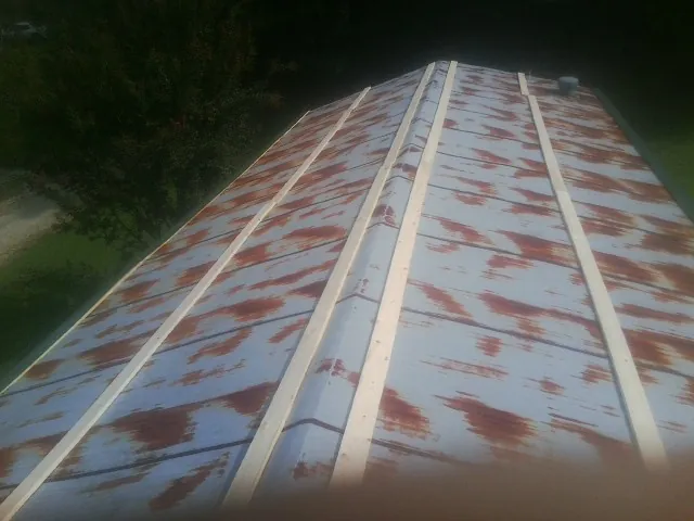 Rusted metal roof panels with new wood purlins before replacement — Storm Damage Roof Repair in Piscataway by Roofing Brothers