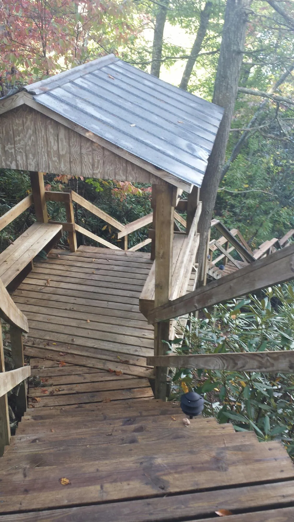 Metal roofed shelter over wooden steps on a wooded walkway — Skylight Repair & Installation work by our crew in Piscataway