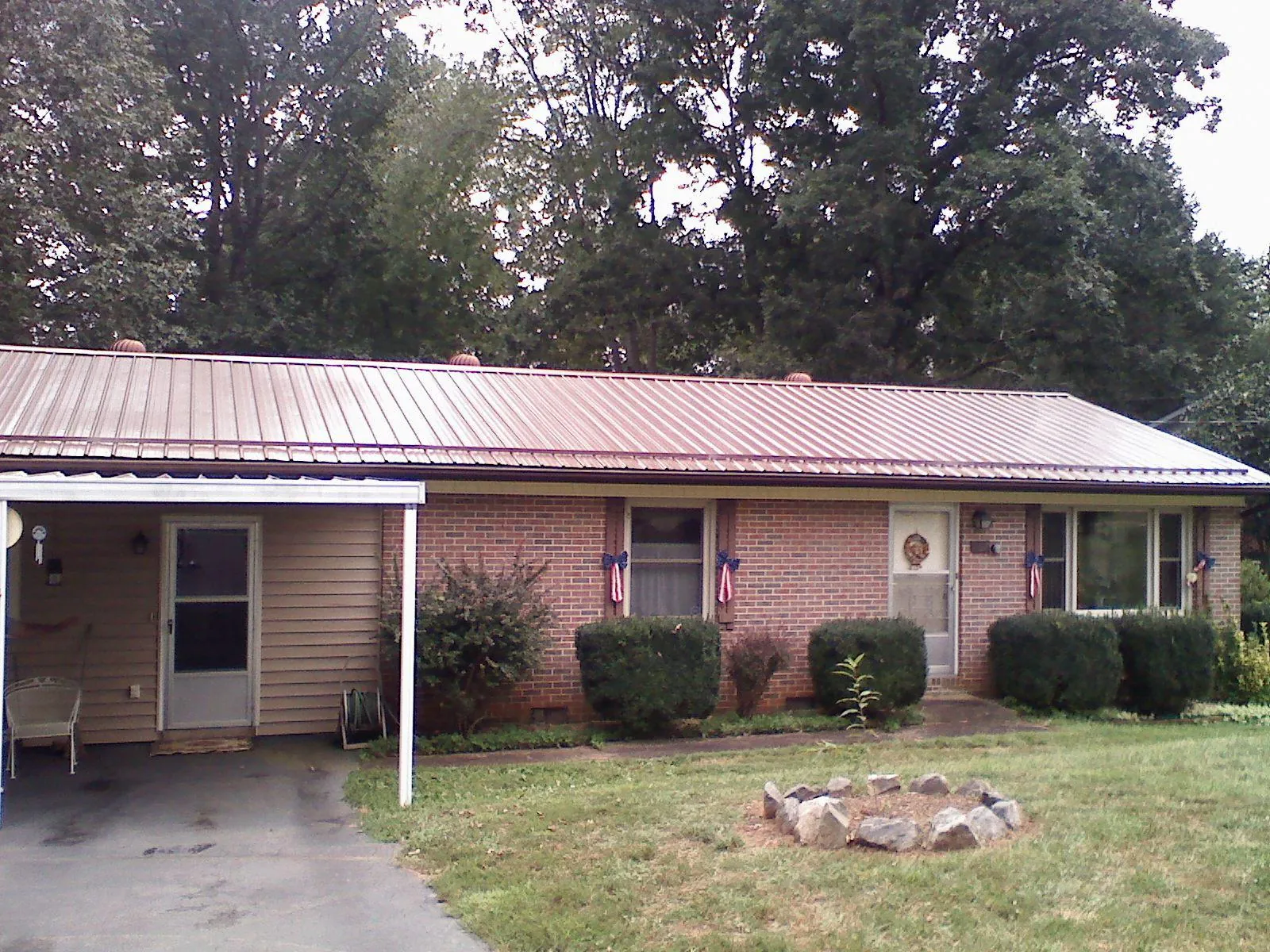 Bronze metal roof and carport on a brick ranch home — Roof Repair work by our crew in Piscataway